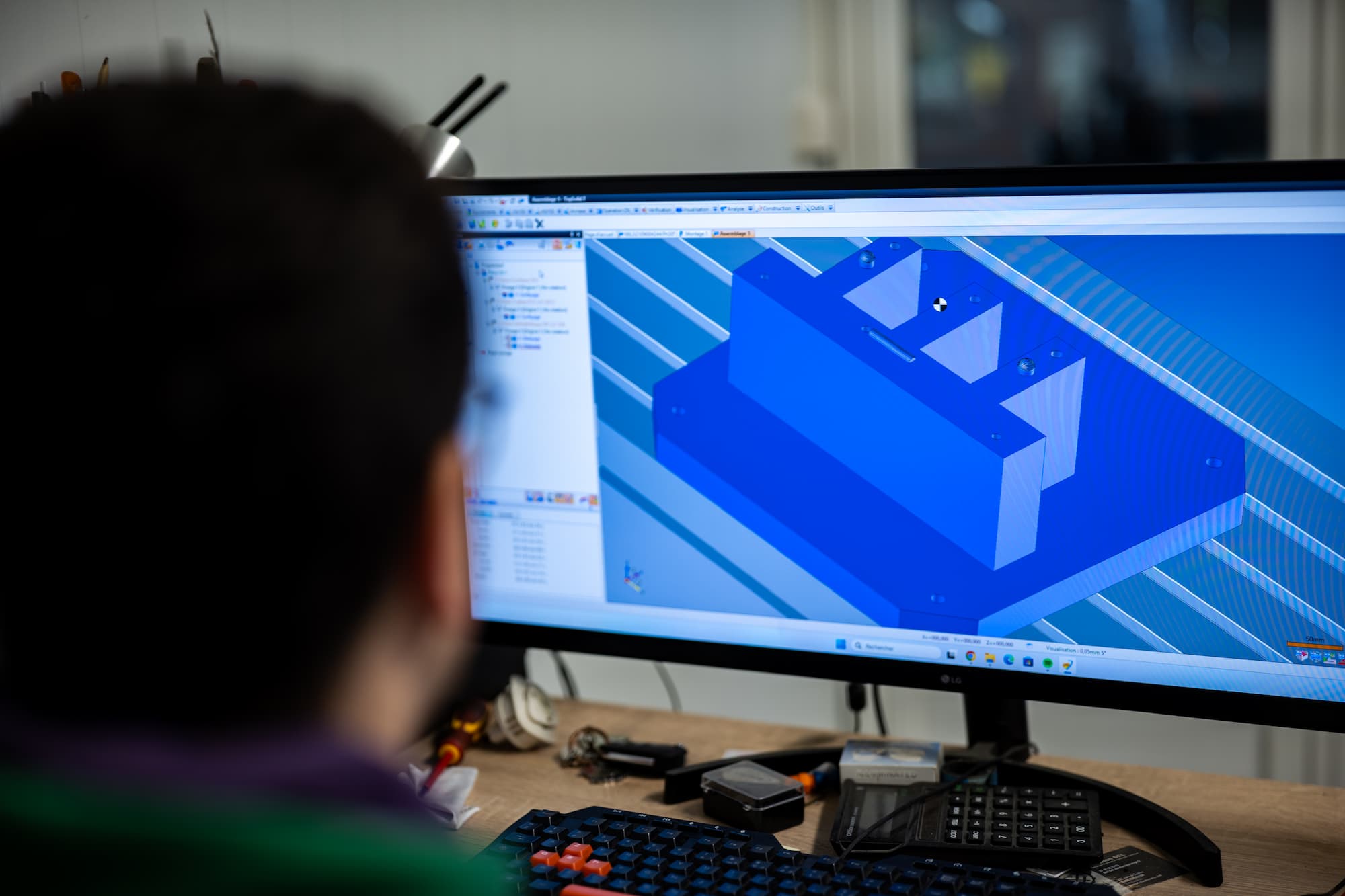 aurelien bel Ingénieur concevant une pièce mécanique en modélisation 3D sur logiciel de CAO pour usinage CNC.