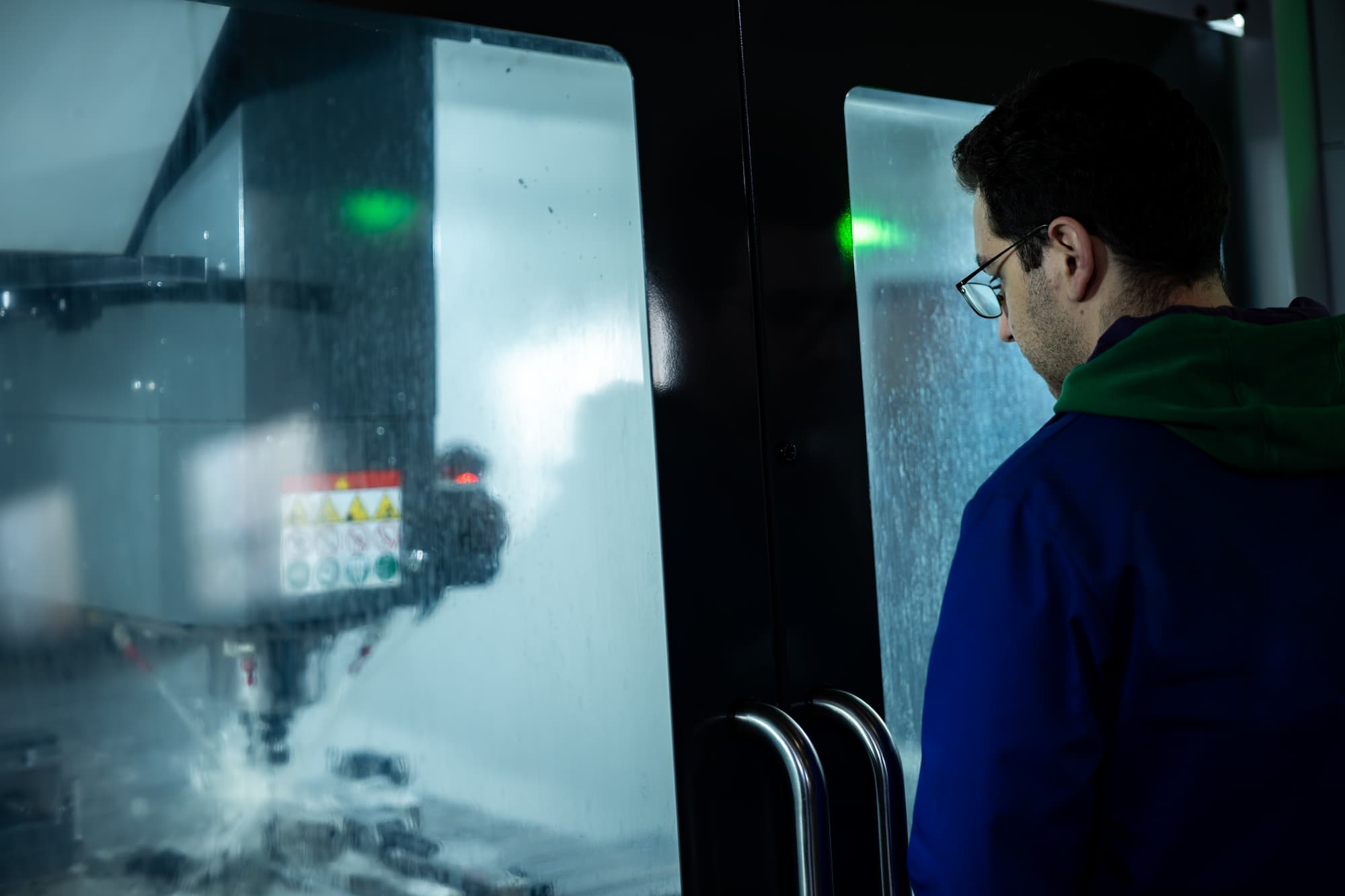 aurelien bel Technicien supervisant une machine CNC en fonctionnement dans un atelier de mécanique de précision.