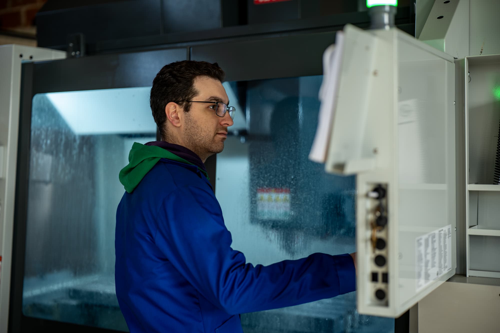 aurelien bel Technicien en usinage CNC en train de piloter un centre d’usinage numérique pour la fabrication de pièces mécaniques de précision en atelier industriel.