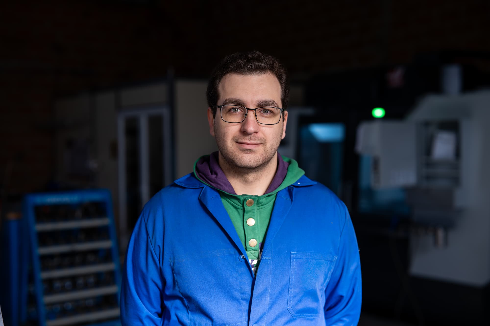 aurelien bel Technicien en usinage industriel posant dans un atelier équipé de machines CNC pour la fabrication de pièces mécaniques de précision.